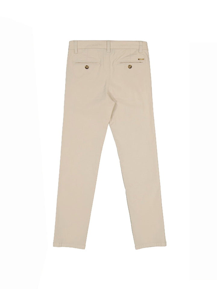Pantalón chino básico para niño en color crema con corte recto y cierre de botón.
