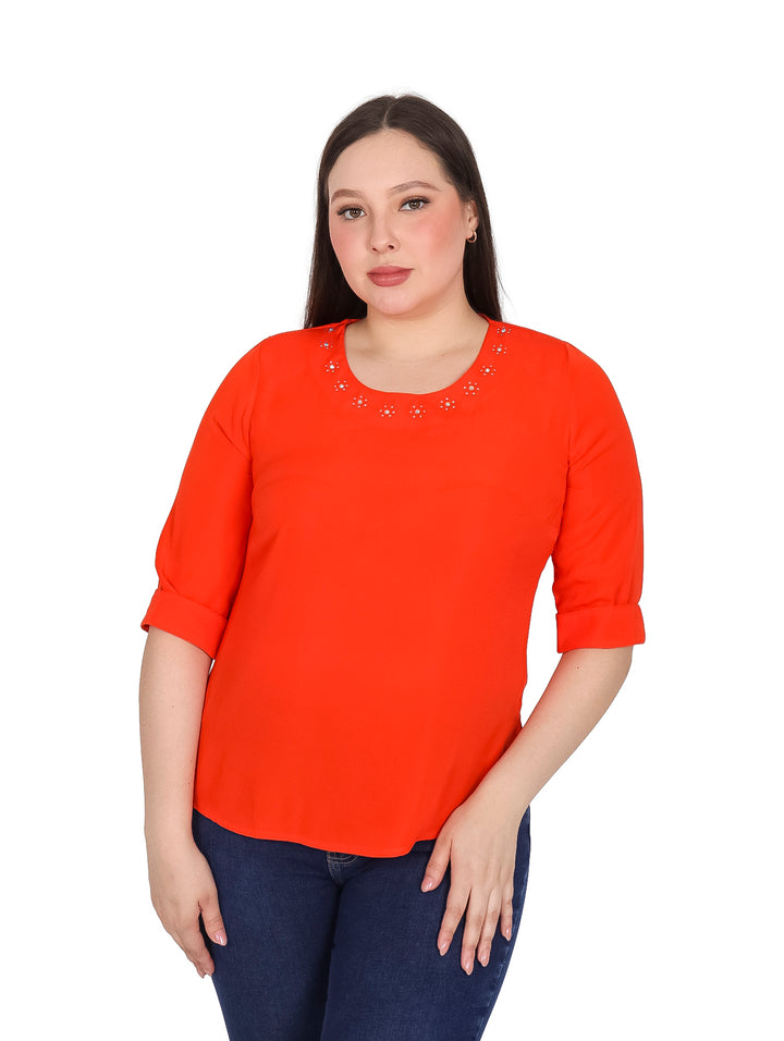 Mujer vistiendo blusa color naranja con manga 3/4 y detalles de piedras brillantes en el cuello.