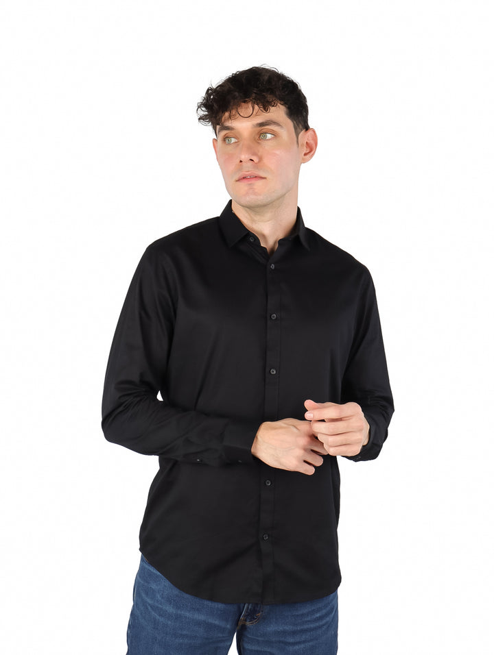 Hombre vistiendo una camisa negra de manga larga con botones.