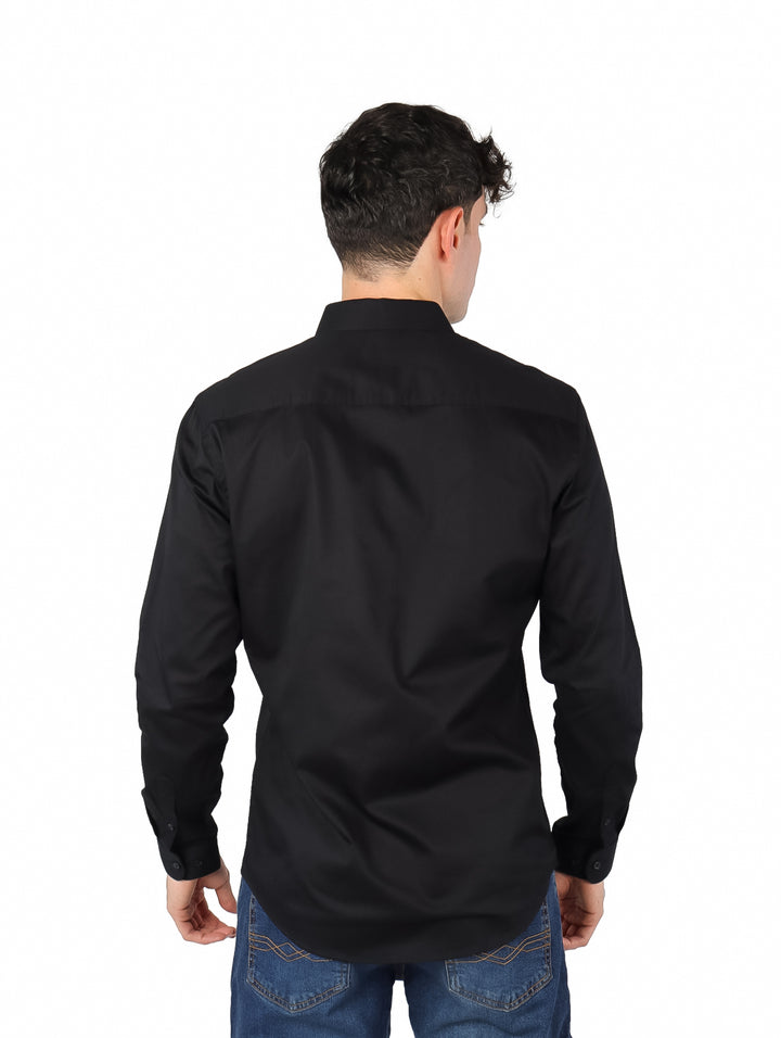Hombre vistiendo una camisa negra de manga larga con botones.