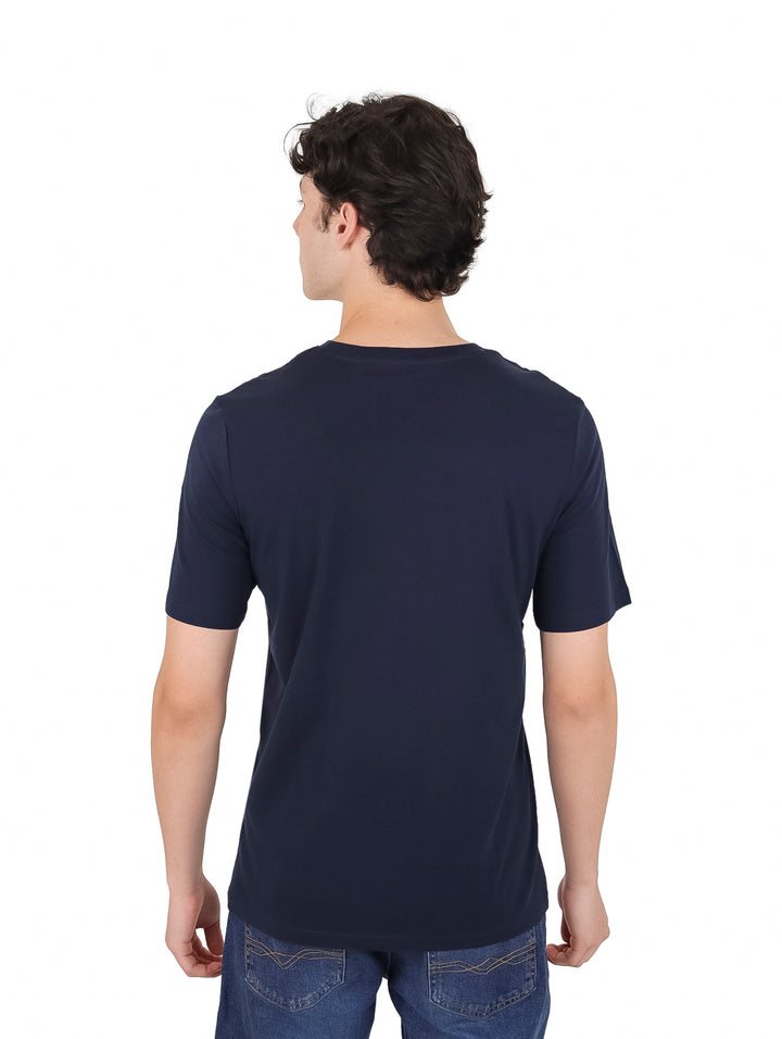 Hombre vistiendo una camiseta azul marino de manga corta con logo de Jack &amp; Jones en el pecho.