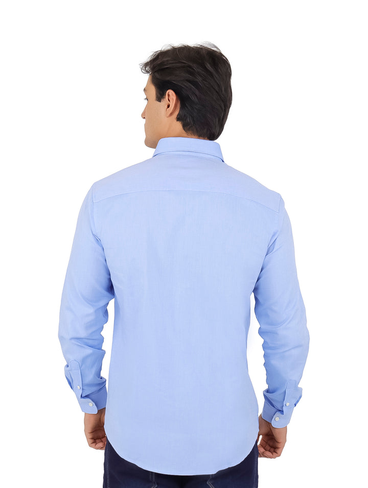 Hombre vistiendo una camisa de manga larga color azul claro.