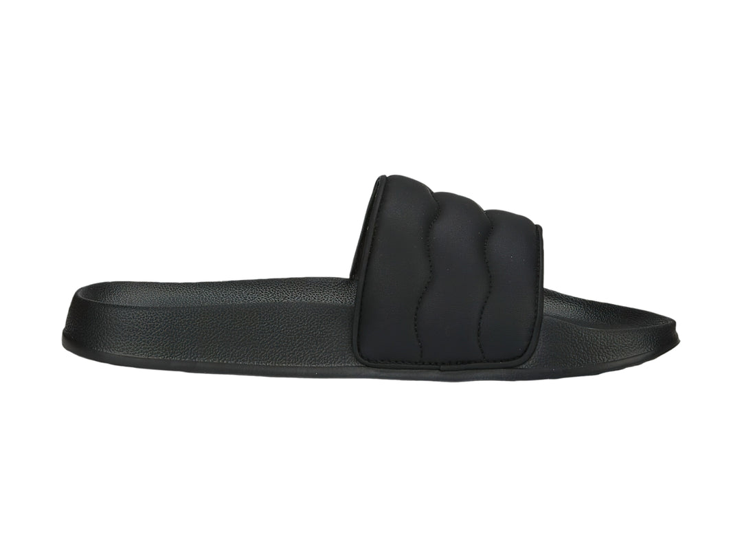 Sandalias PUMA negras con correa acolchada y logotipo dorado.