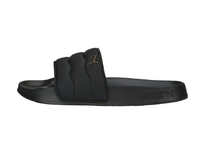 Sandalias PUMA negras con correa acolchada y logotipo dorado.