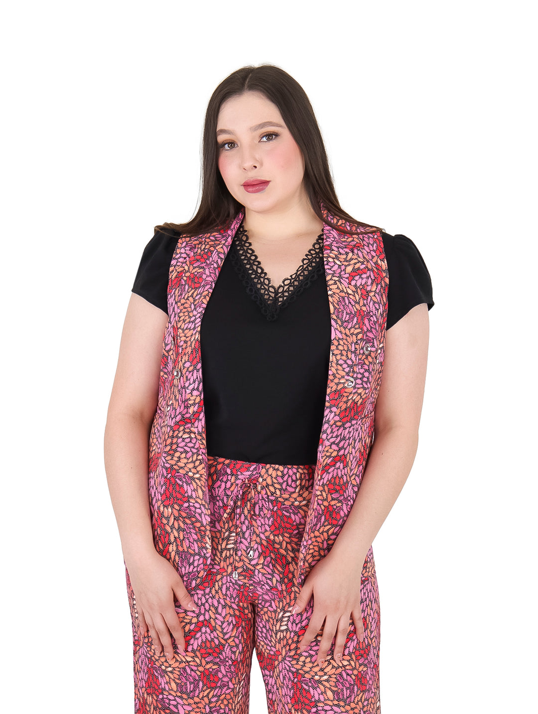Mujer vistiendo un chaleco largo estampado en tonos fiushia y naranja sobre una blusa negra.