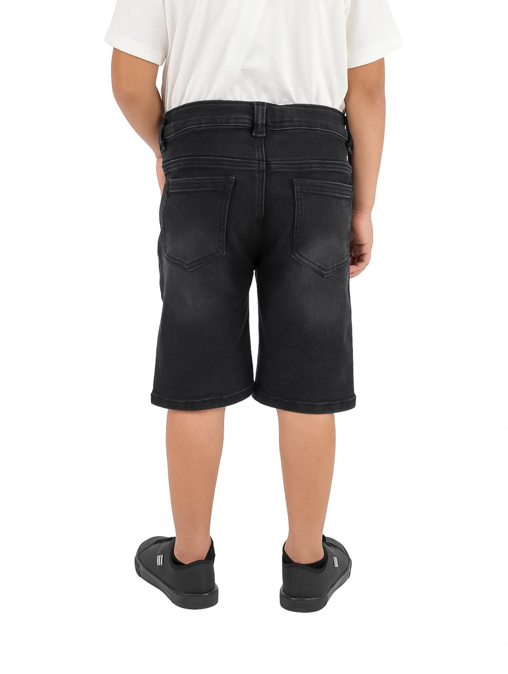 Niño vistiendo un short de mezclilla color negro y calzado negro sobre fondo blanco.