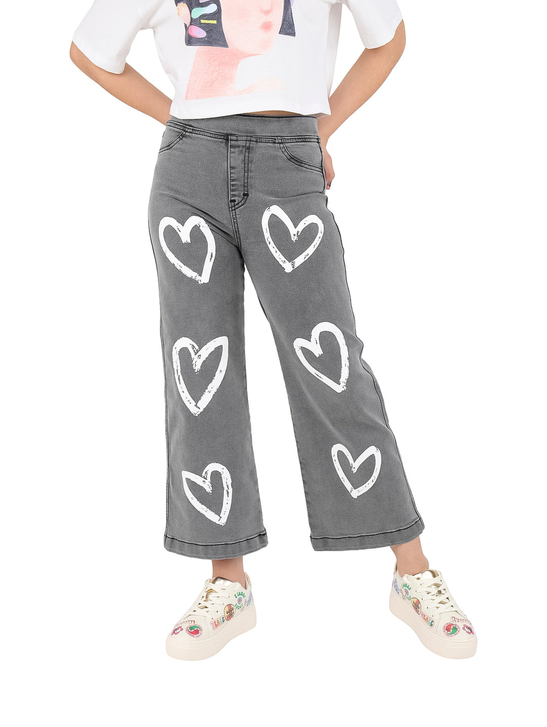 Pantalón de mezclilla gris para niña con estampado de corazones blancos.