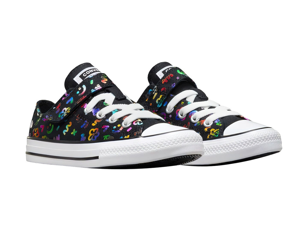 Tenis Converse infantiles negros con patrones coloridos, suela blanca y correa de velcro.