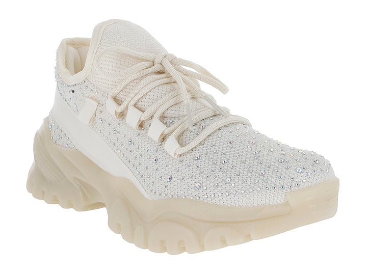 Tenis color beige con suela chunky y detalles de brillantes en la parte superior.