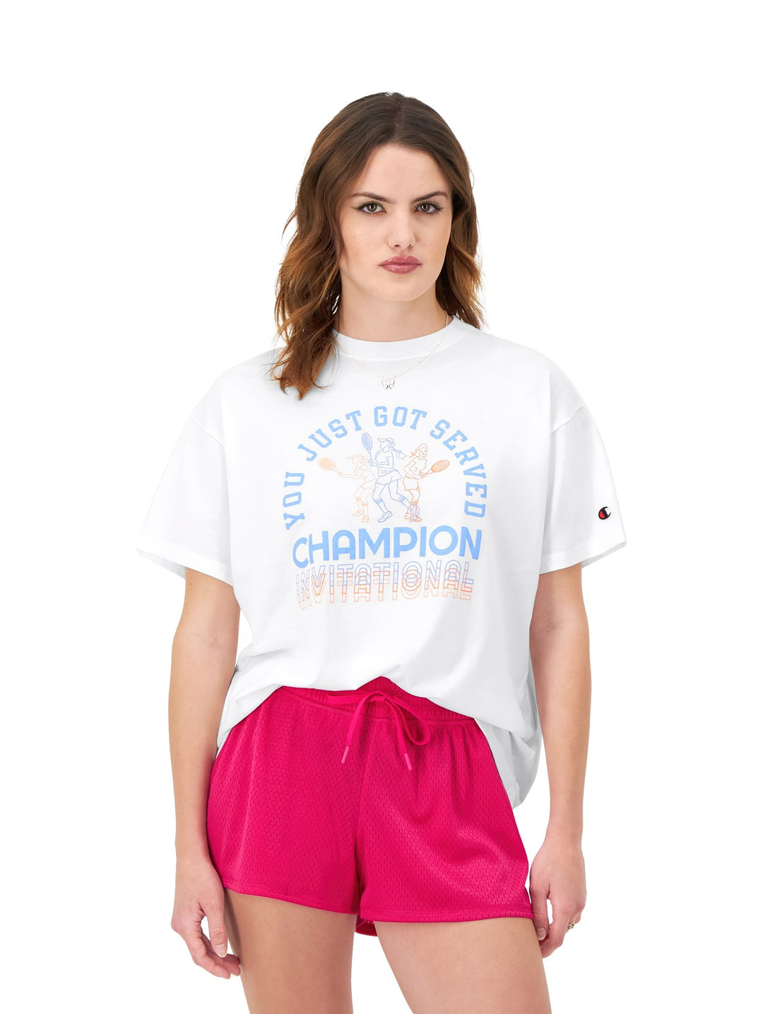Mujer vistiendo una camiseta blanca de corte holgado con estampado gráfico de Champion.