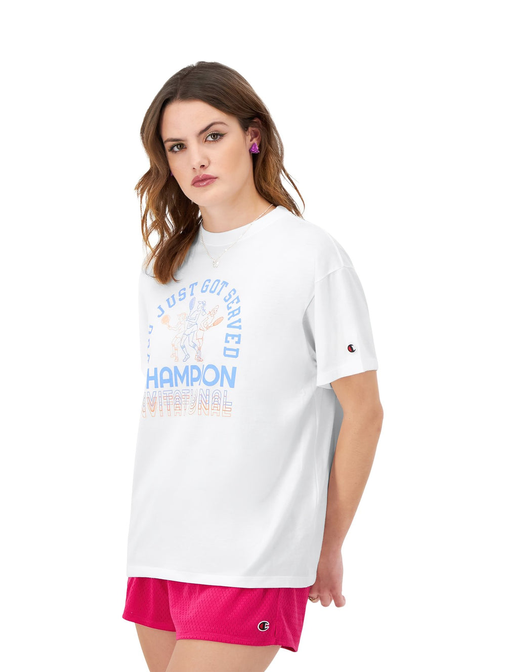 Mujer vistiendo una camiseta blanca de corte holgado con estampado gráfico de Champion.