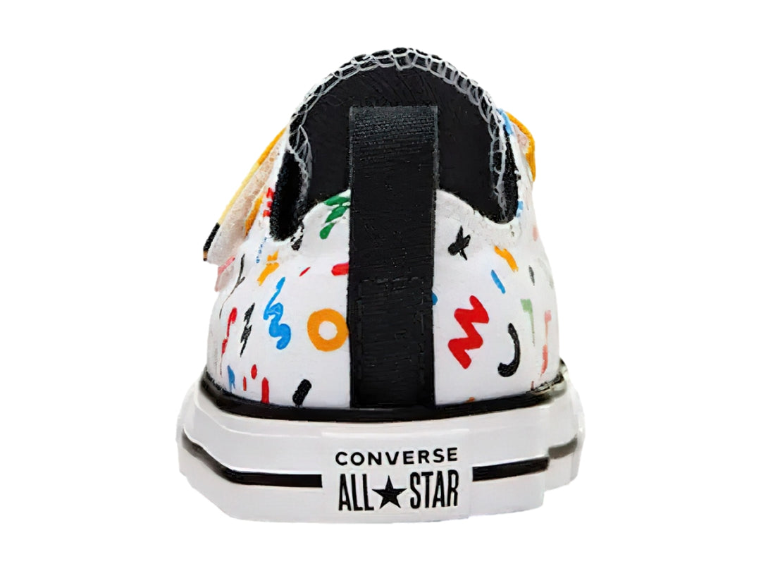 Tenis Converse blancos con dibujos coloridos y correas de velcro en forma de lápices.