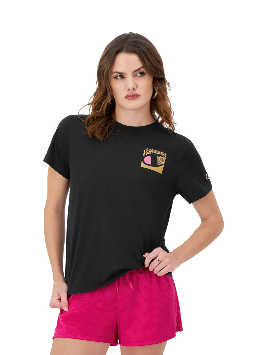 Mujer vistiendo una camiseta negra de manga corta marca Champion con un logo estampado en el pecho.