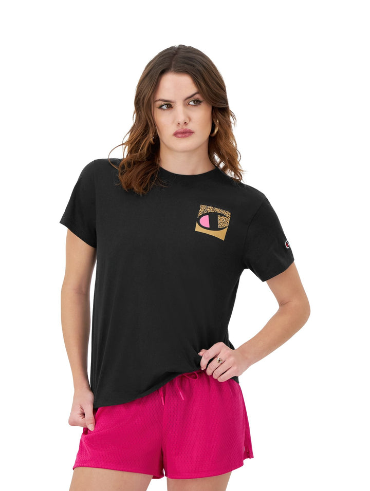 Mujer vistiendo una camiseta negra de manga corta marca Champion con un logo estampado en el pecho.