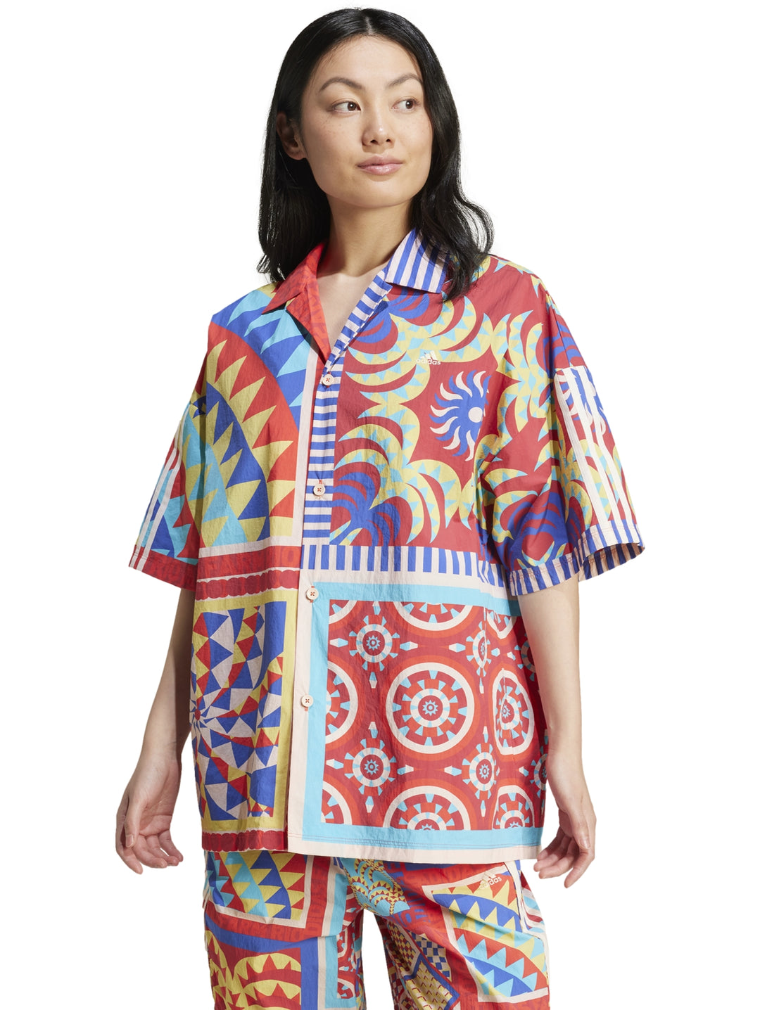 Mujer vistiendo camisa Adidas x Farm Rio multicolor con estampados geométricos y florales