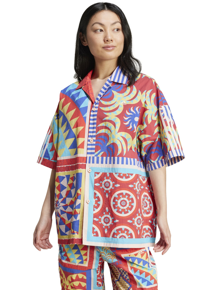 Mujer vistiendo camisa Adidas x Farm Rio multicolor con estampados geométricos y florales