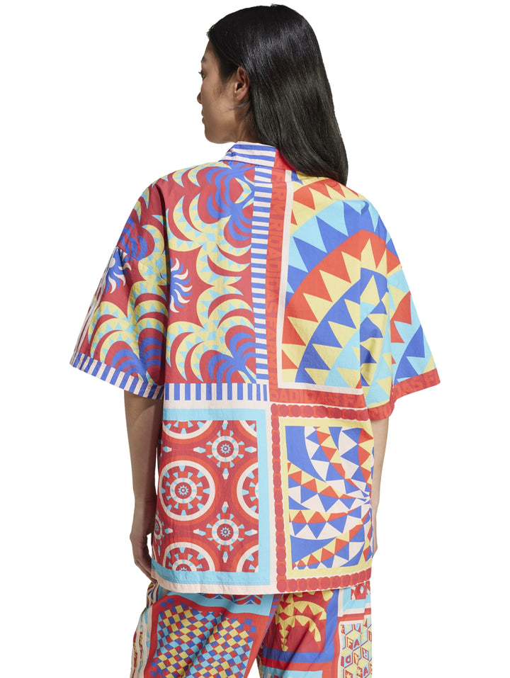 Mujer vistiendo camisa Adidas x Farm Rio multicolor con estampados geométricos y florales