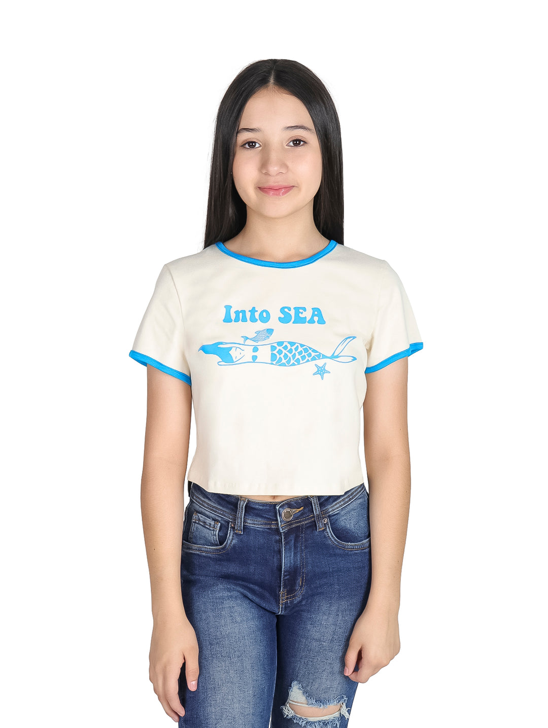 Niña vistiendo camiseta corta color crema con estampado de sirena y bordes en color azul.