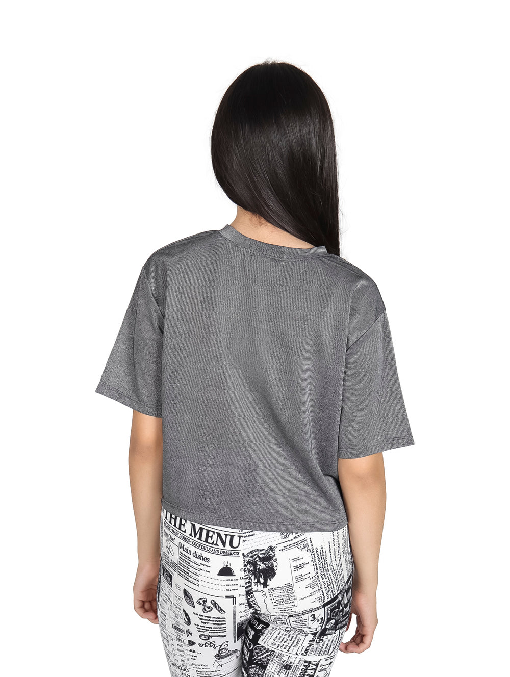 Niña vistiendo camiseta negra con brillos de manga corta y cuello redondo.
