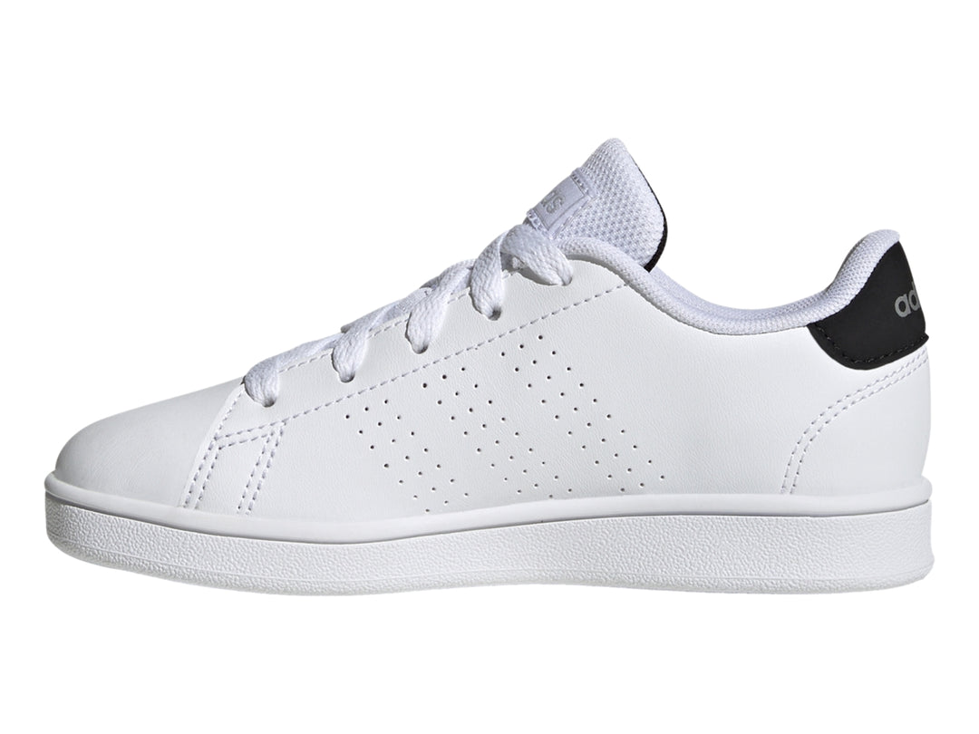 Tenis blancos Adidas Advantage K con talón negro y suela blanca.