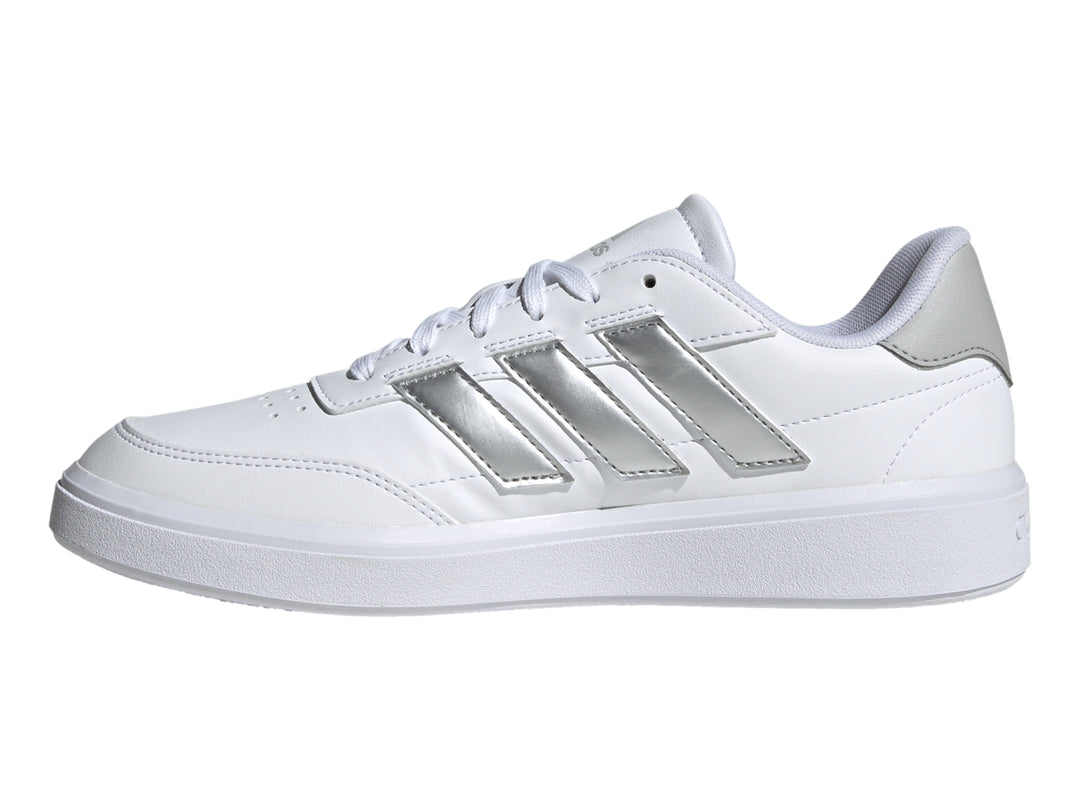 Tenis Adidas blancos con tres franjas plateadas y detalle gris en el talón.