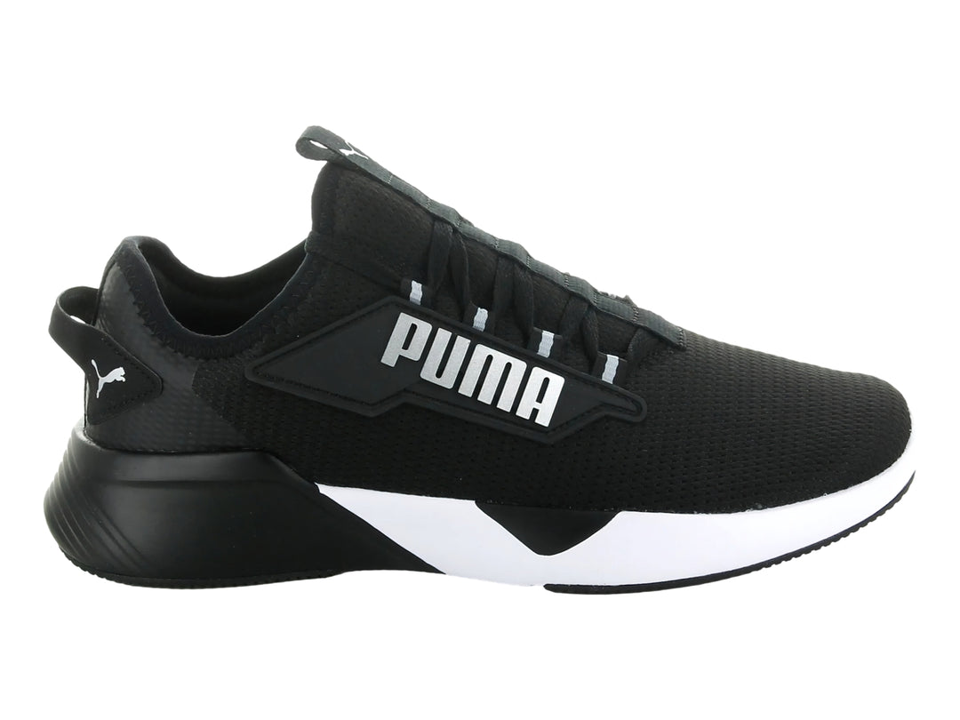 Tenis deportivos PUMA Retaliate 2 en color negro con suela blanca y logotipo plateado lateral.