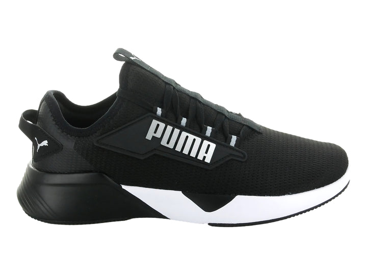 Tenis deportivos PUMA Retaliate 2 en color negro con suela blanca y logotipo plateado lateral.
