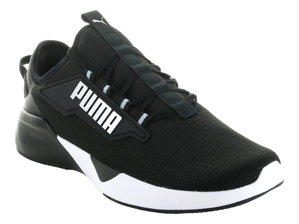Tenis deportivos PUMA Retaliate 2 en color negro con suela blanca y logotipo plateado lateral.