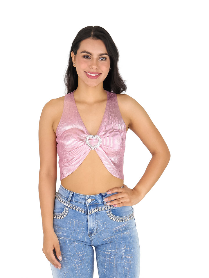 Mujer vistiendo una blusa crop top rosa sin mangas con un detalle de corazón plateado en el centro.
