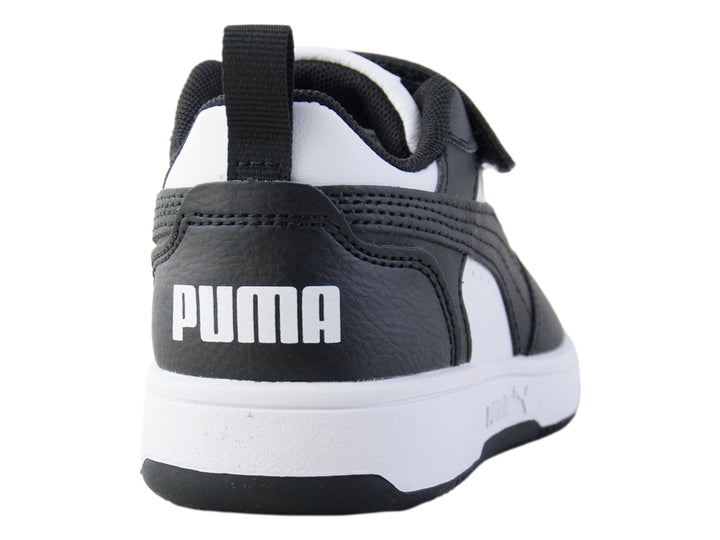 Tenis PUMA Rebound V6 Lo AC+PS en colores blanco y negro con cierre de velcro para niños.