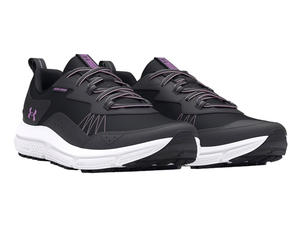 Tenis deportivos Under Armour en color negro con suela blanca y detalles en morado.