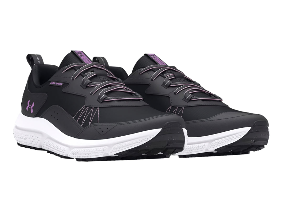 Tenis deportivos Under Armour en color negro con suela blanca y detalles en morado.