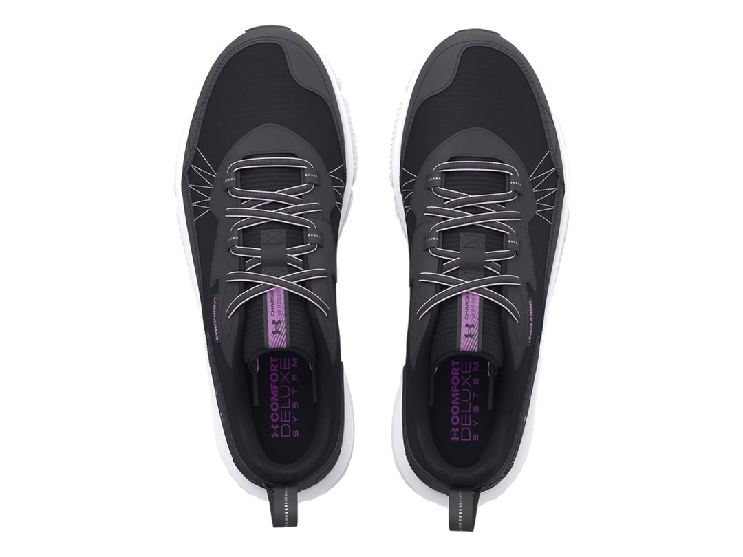 Tenis deportivos Under Armour en color negro con suela blanca y detalles en morado.
