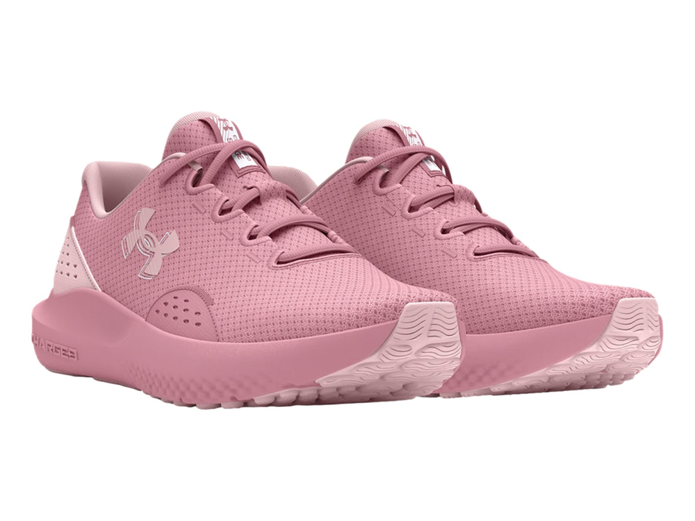 Tenis deportivos Under Armour de color rosa con suela Charged y malla transpirable.
