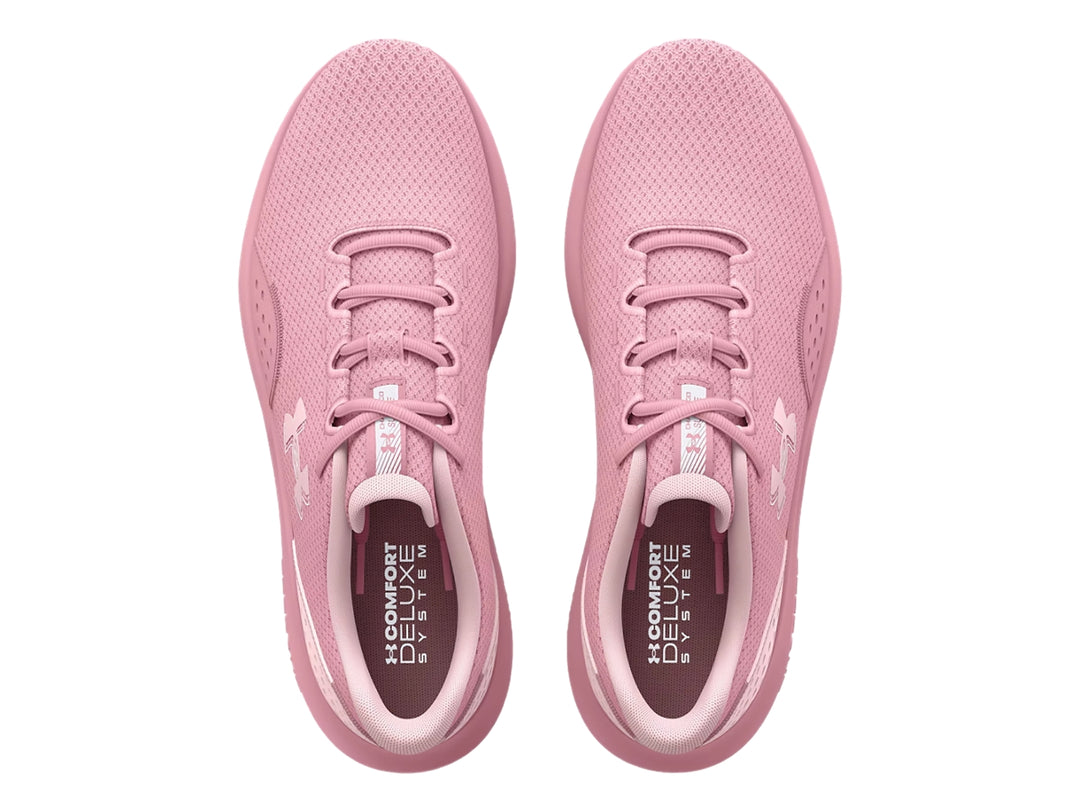 Tenis deportivos Under Armour de color rosa con suela Charged y malla transpirable.