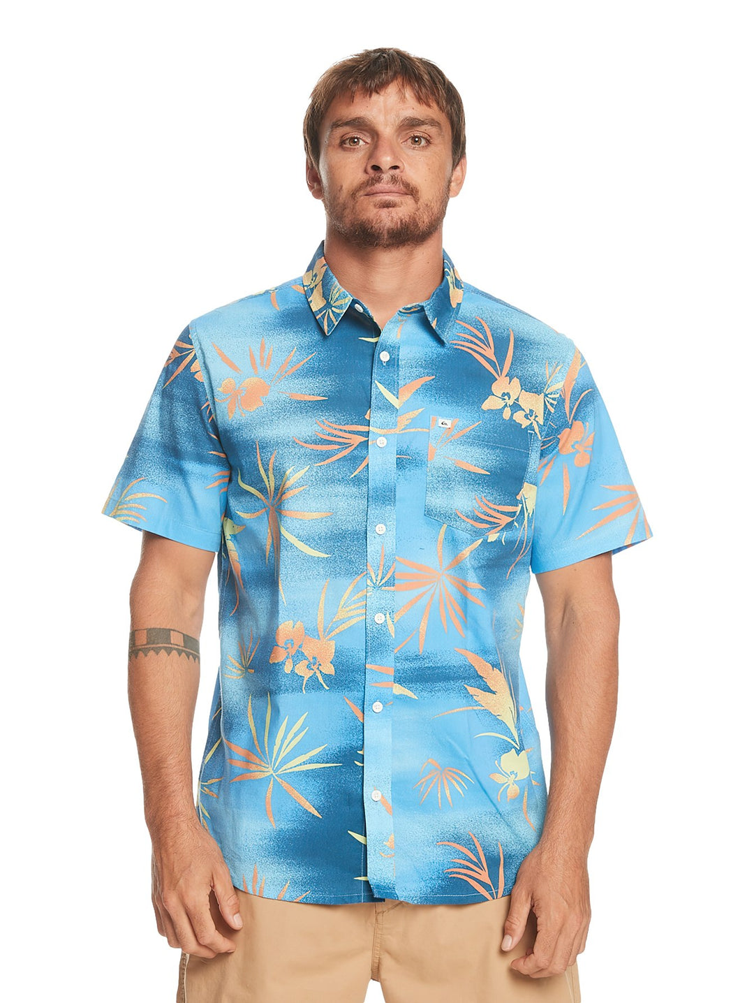 Camisa de manga corta Quiksilver color azul con estampado de hojas tropicales en tonos naranja y amarillo.