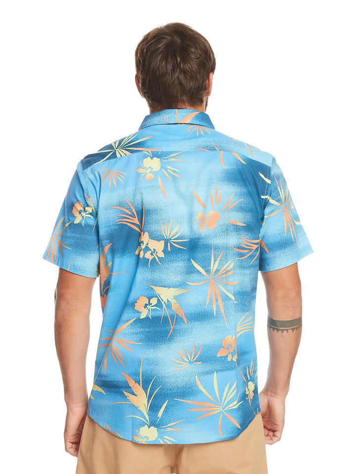 Camisa de manga corta Quiksilver color azul con estampado de hojas tropicales en tonos naranja y amarillo.