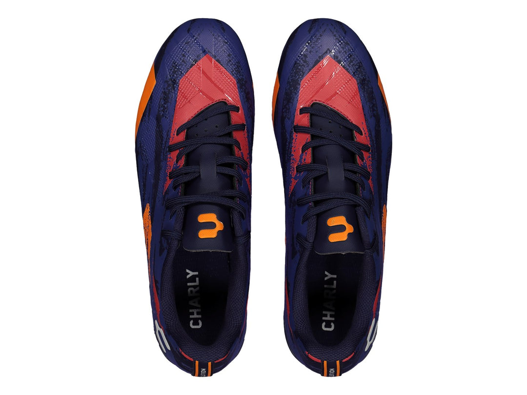 Calzado de fútbol Charly en color azul marino con detalles geométricos en naranja y rojo.