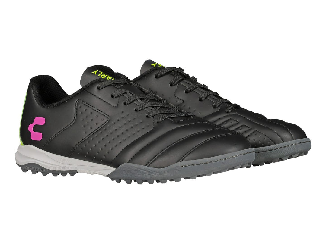 Zapato de fútbol Charly negro con detalles en verde lima y rosa, suela para césped sintético.