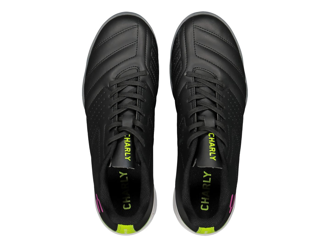 Zapato de fútbol Charly negro con detalles en verde lima y rosa, suela para césped sintético.
