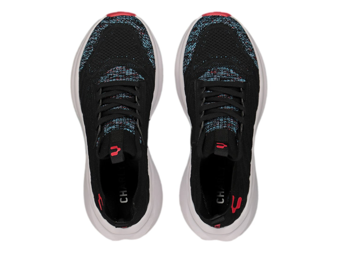 Tenis deportivos Charly color negro con suela blanca y detalles rojos y multicolores en la punta.