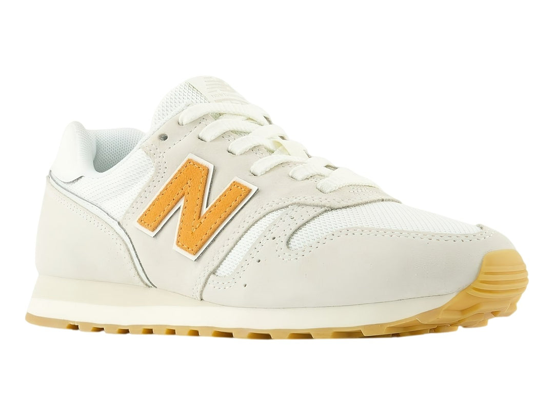 Tenis New Balance 373 color Sea Salt con suela de goma y logotipo N en color naranja.