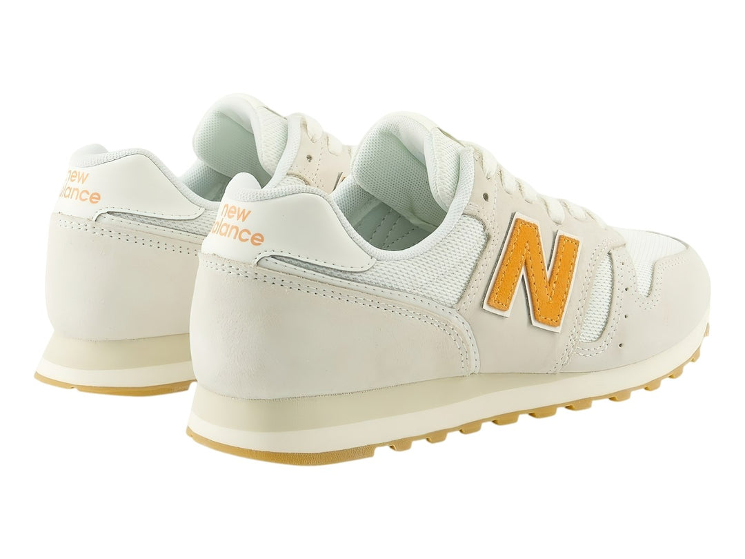 Tenis New Balance 373 color Sea Salt con suela de goma y logotipo N en color naranja.