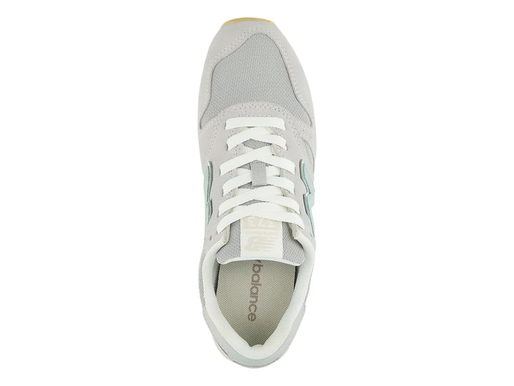 Tenis New Balance 373 color gris Raincloud con detalles en azul claro y suela color goma.