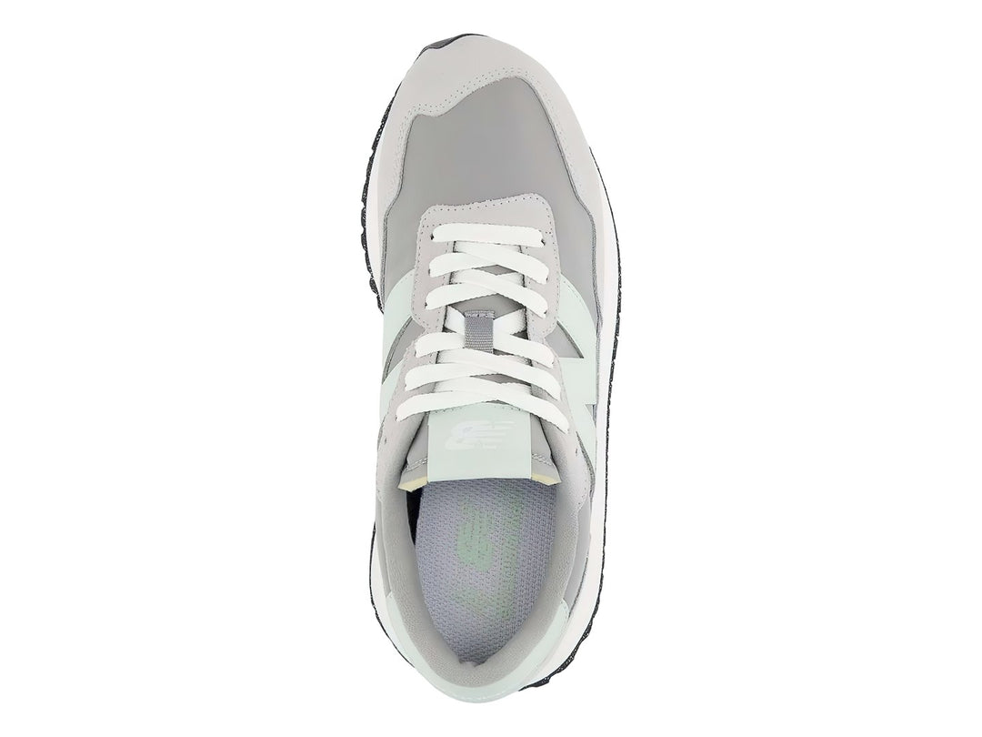 Tenis New Balance color gris pizarra con suela blanca y detalles en verde menta.