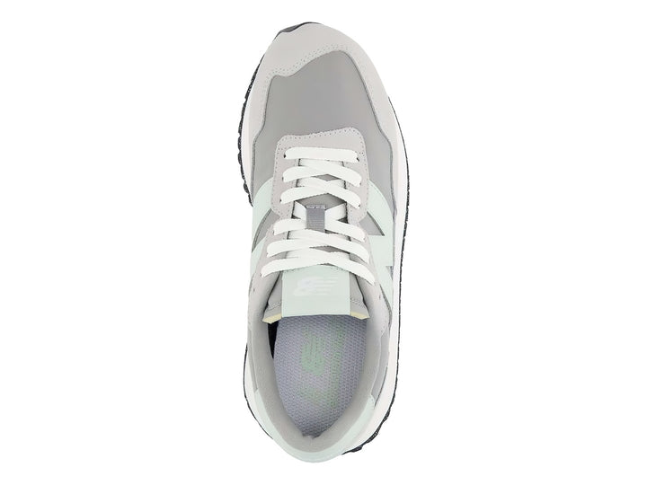Tenis New Balance color gris pizarra con suela blanca y detalles en verde menta.