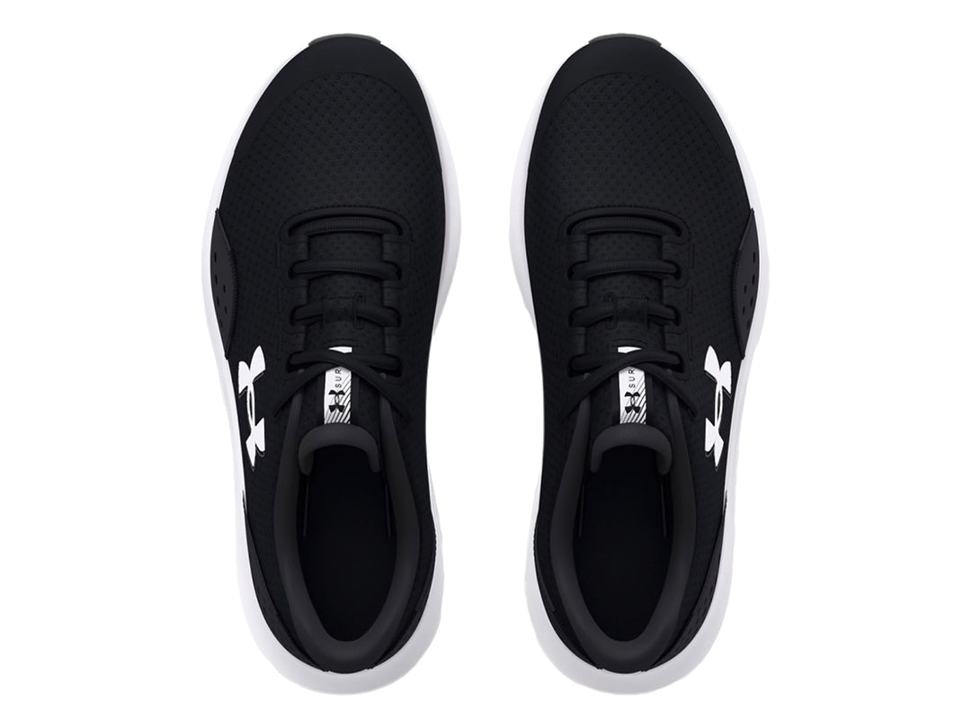 Tenis deportivos Under Armour Surge 4 en color negro con suela blanca para niños.