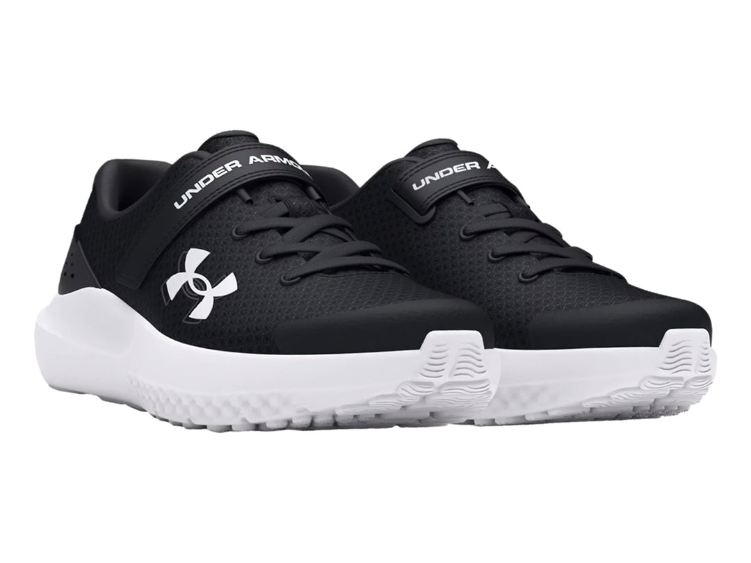 Tenis deportivos Under Armour color negro con suela blanca y cierre de correa y agujetas.