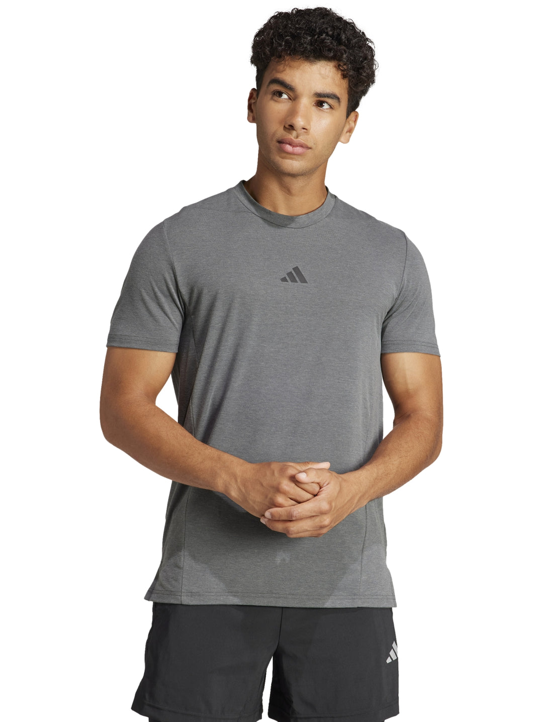 Hombre vistiendo playera de entrenamiento Adidas en color gris sólido con logo central.