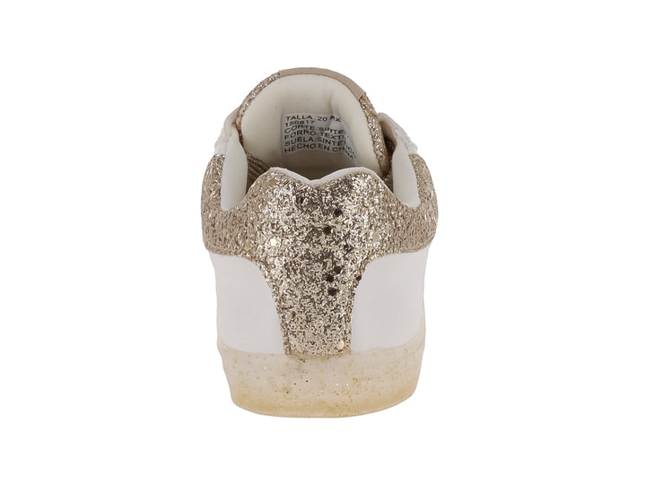Tenis infantiles blancos con detalles brillantes en color oro, incluyendo una estrella lateral y punta brillante.